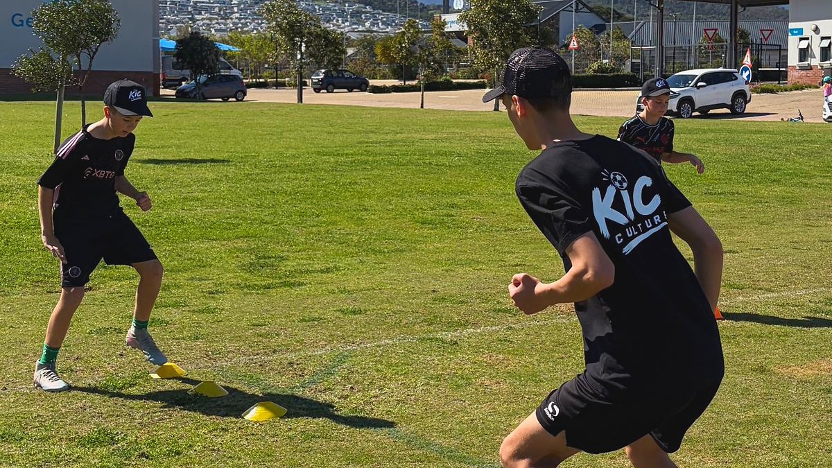 A KicCulture coach taking a player on one against one through a grid of cones.